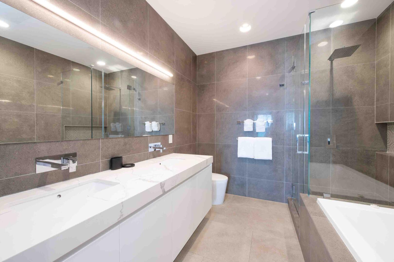 Primary Ensuite with dual vanity, soaking bathtub, and separate shower.