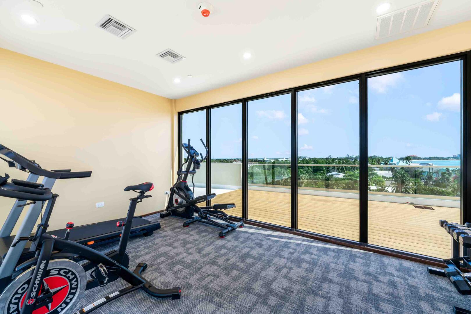 The rooftop includes a fitness studio equipped with a treadmill and elliptical, plus a stationary bike and a rack of free weights.