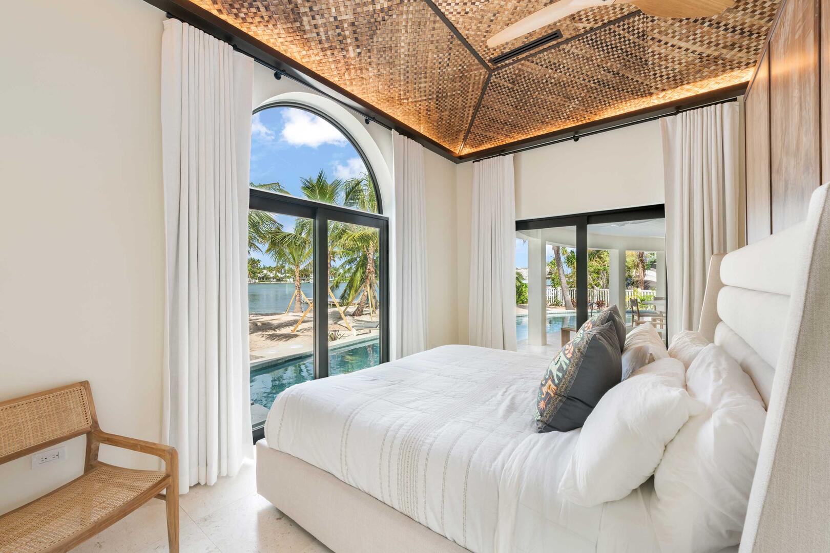 Bedroom 3 on the lower level with king bed and walkout access to the pool-side veranda or beach.