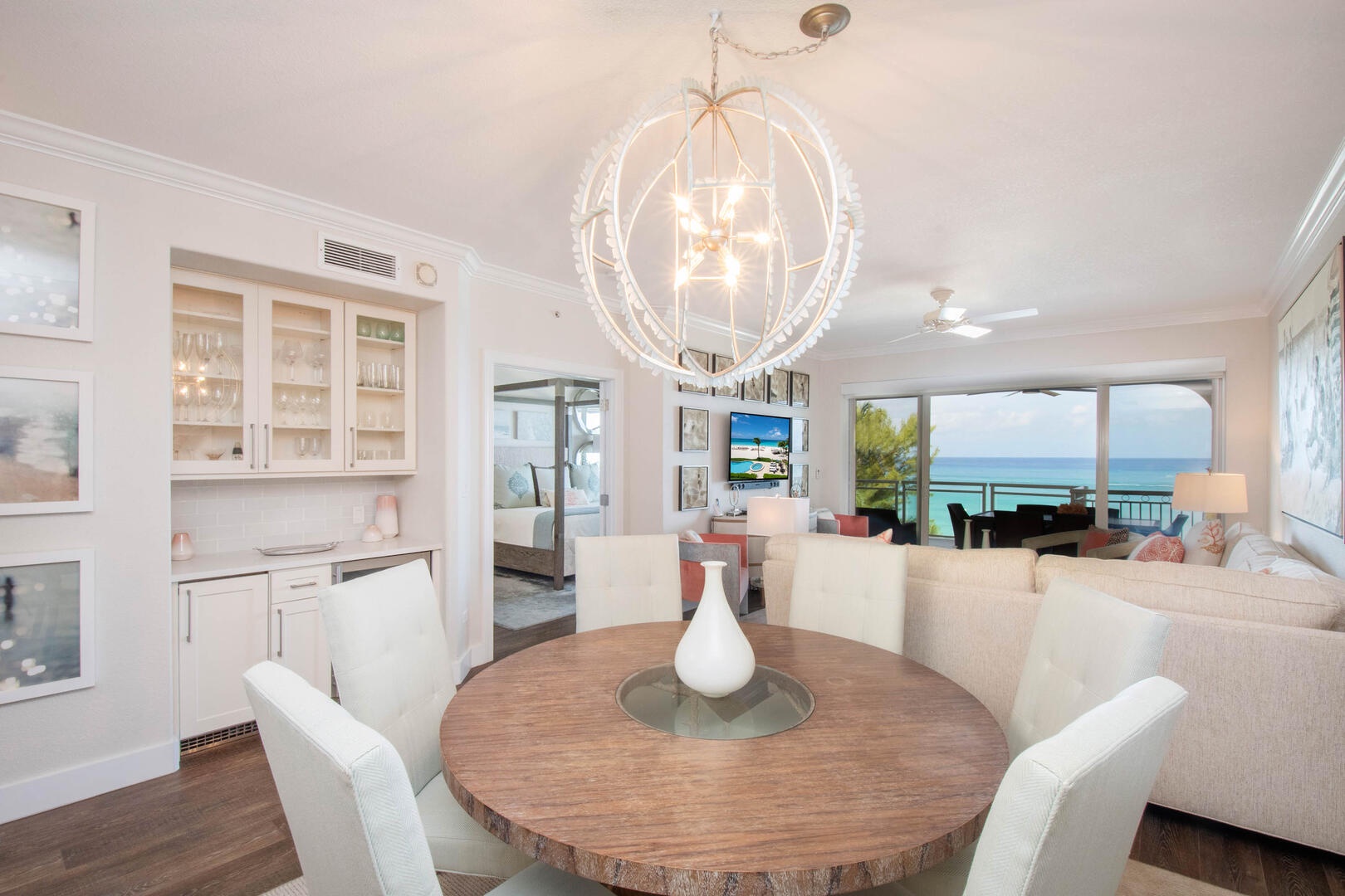 Dining area with modern chandelier and cabinets.