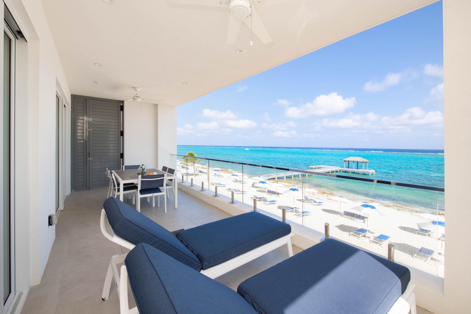 Private balcony furnished with sun loungers and an al fresco dining table.