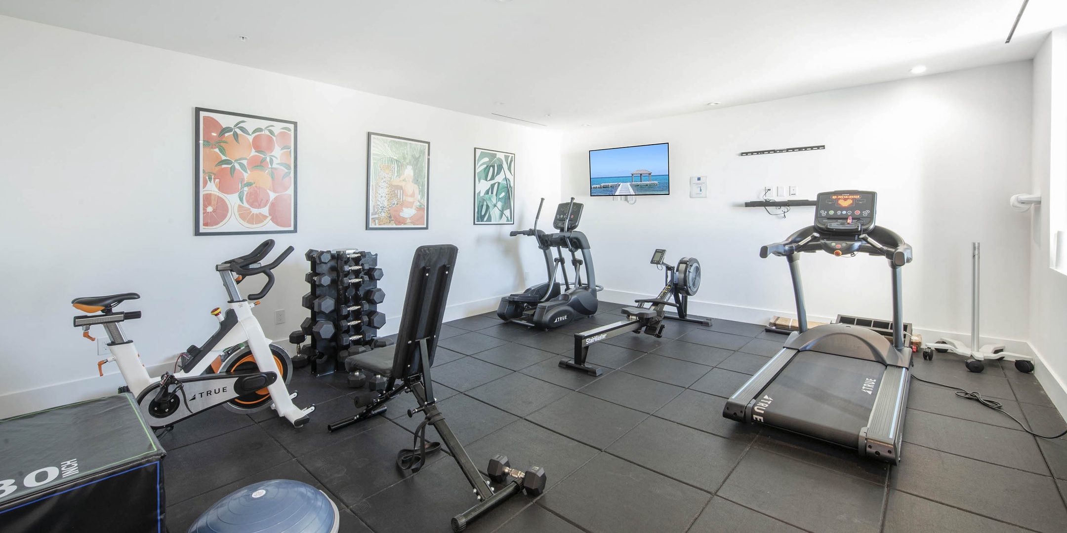 Resort fitness center with cardio machines and free weights.