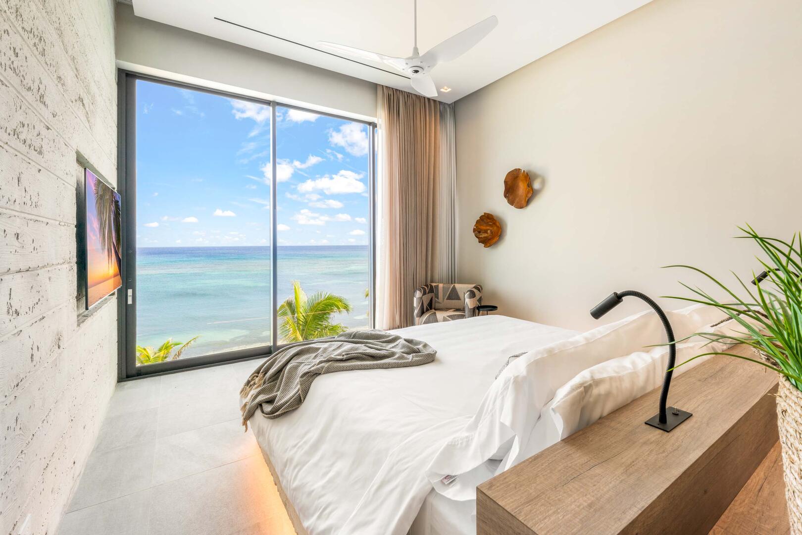 Oceanfront king suite 1 - king platform bed, desk, oceanfront floor-to-ceiling glass doors, 65" TV w/swivel mount, beverage fridge, coffee center, upholstered chair, sofa