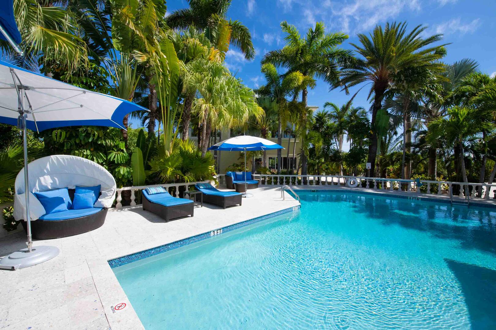 Kaiku's large pool deck with sun beds, loungers, and shade umbrellas.