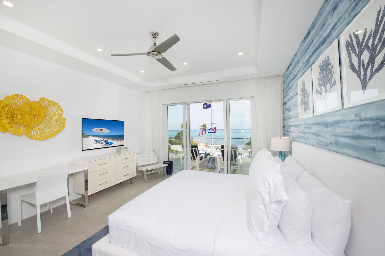 Primary Suite with king bed, television, and walk-out access to the balcony.