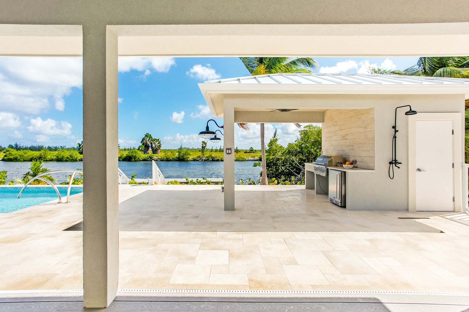 Outdoor grilling cabana with propane grill and counter space. Outdoor shower to the left of the door.
