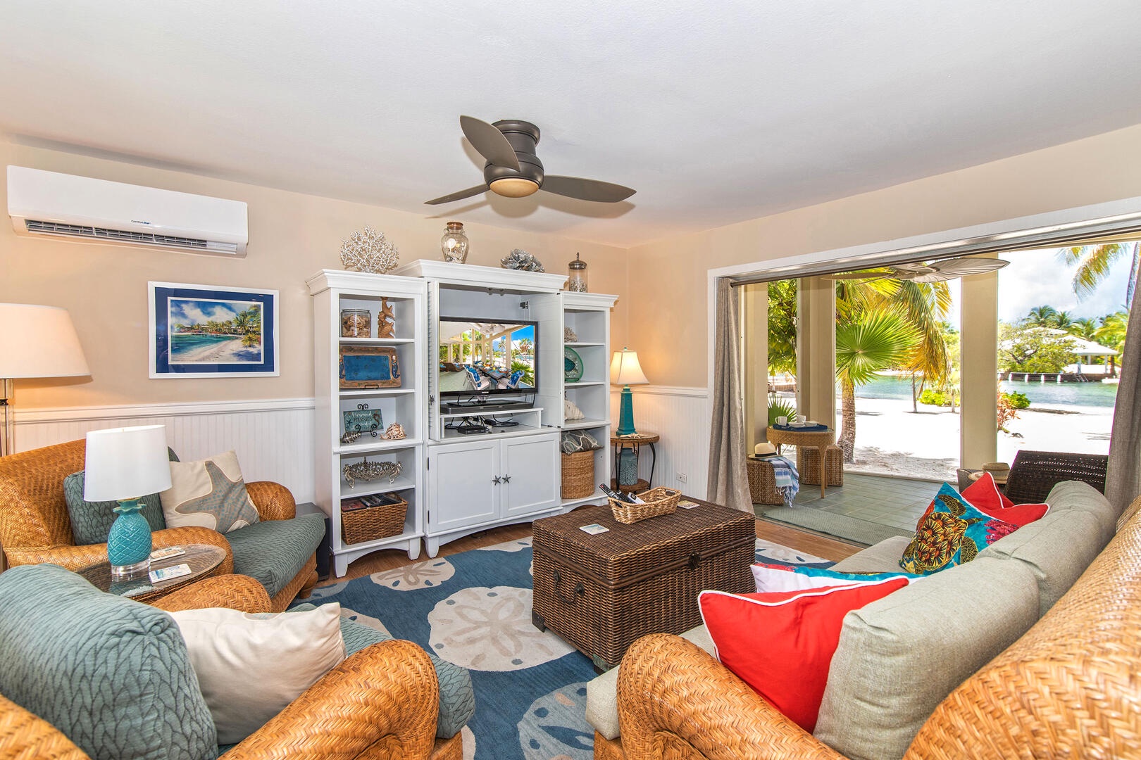 Cozy living area with sofa seating, cable television, and walkout access to the screened atrium.