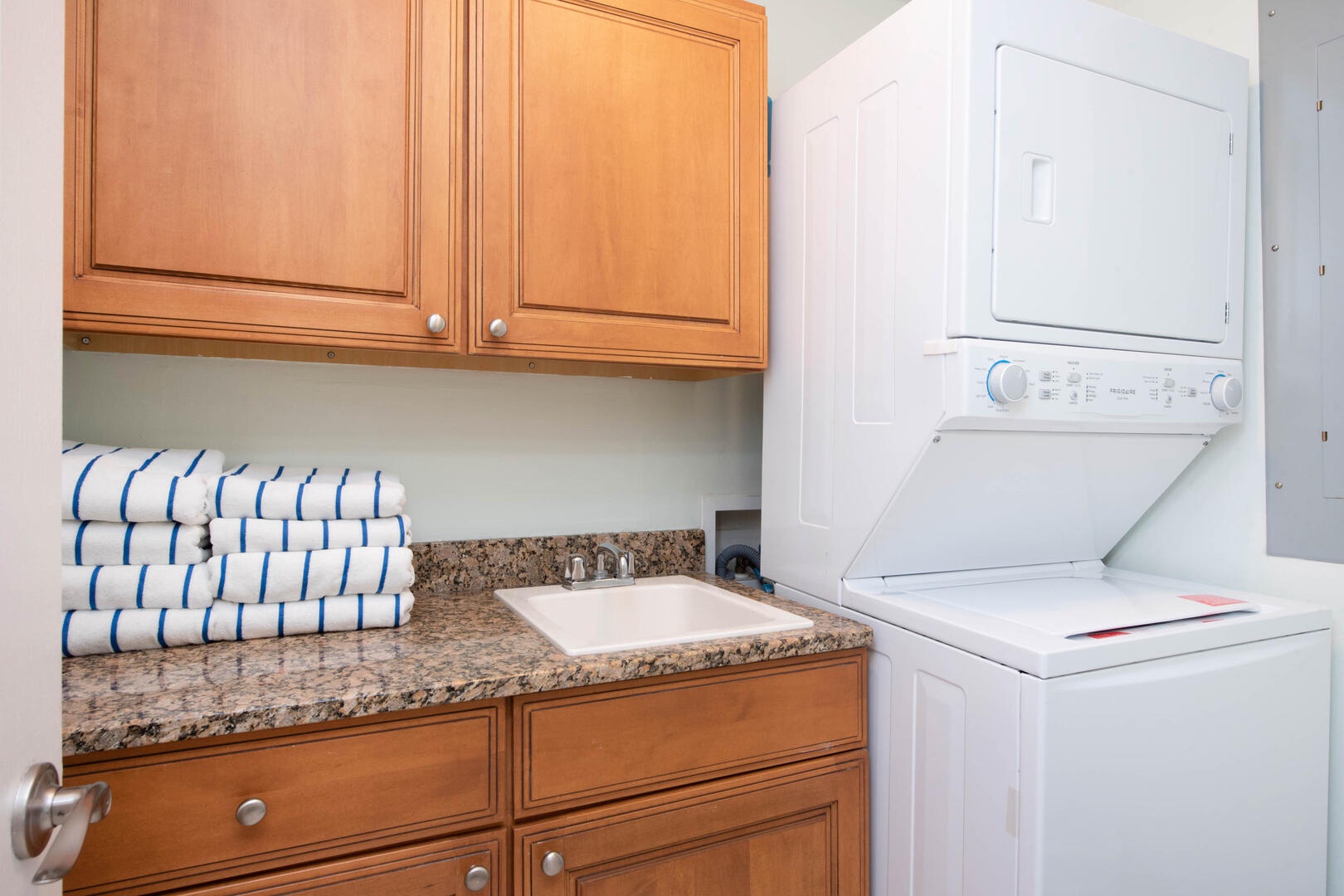 In-unit laundry room with stacked washer and dryer.