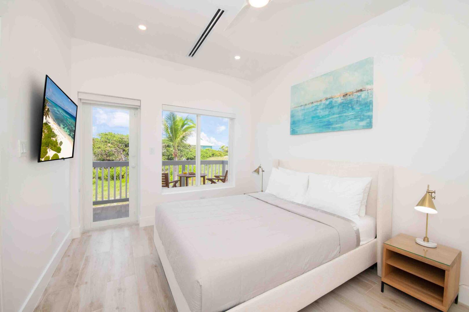 Bedroom 3 with queen bed, television, and walkout access to a shared balcony.