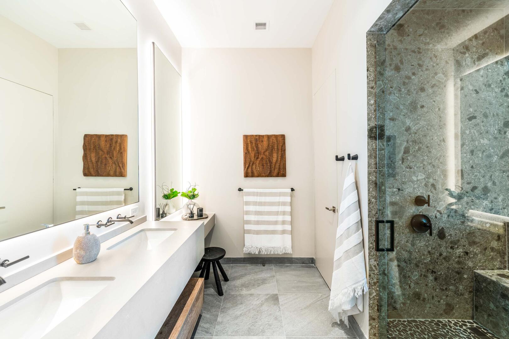 Suite 3 ensuite bathroom with double vanity, multiple mirrors, lighted make-up desk, walk-in oceanview shower