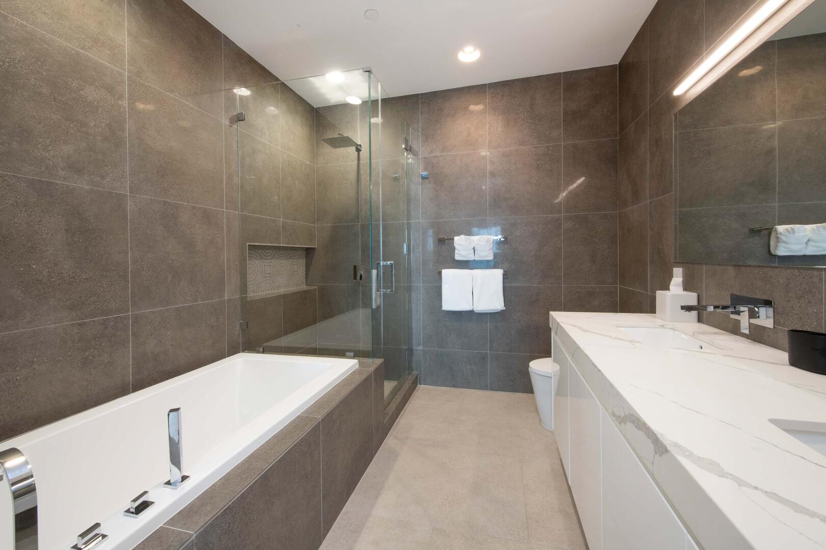 Primary Ensuite with dual vanities, walk-in shower, and soaking tub.