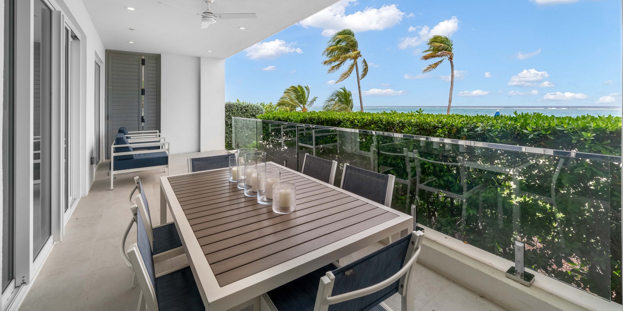 Ocean terrace with alfresco dining table and privacy hedge.