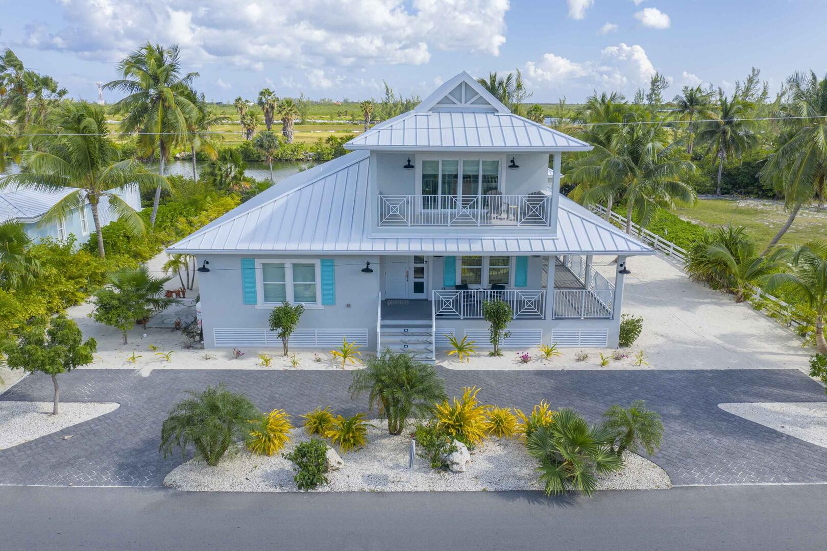 Front of villa with large driveway.