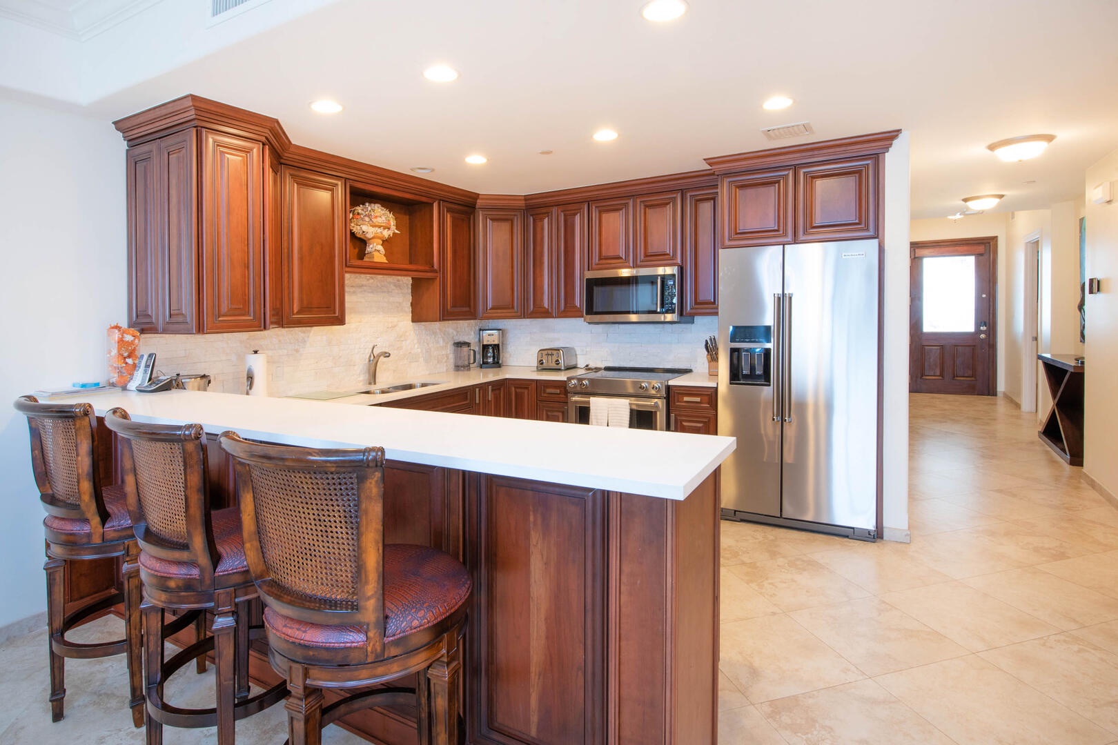 Full kitchen stocked with dishware, cookware, glassware, and cutlery.