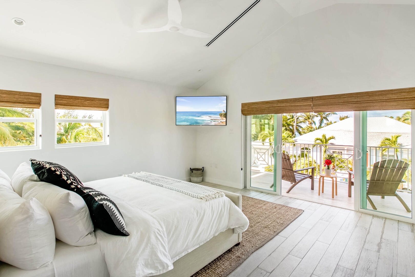 Upper suite with king bed, television, and walk-out access to a private balcony.