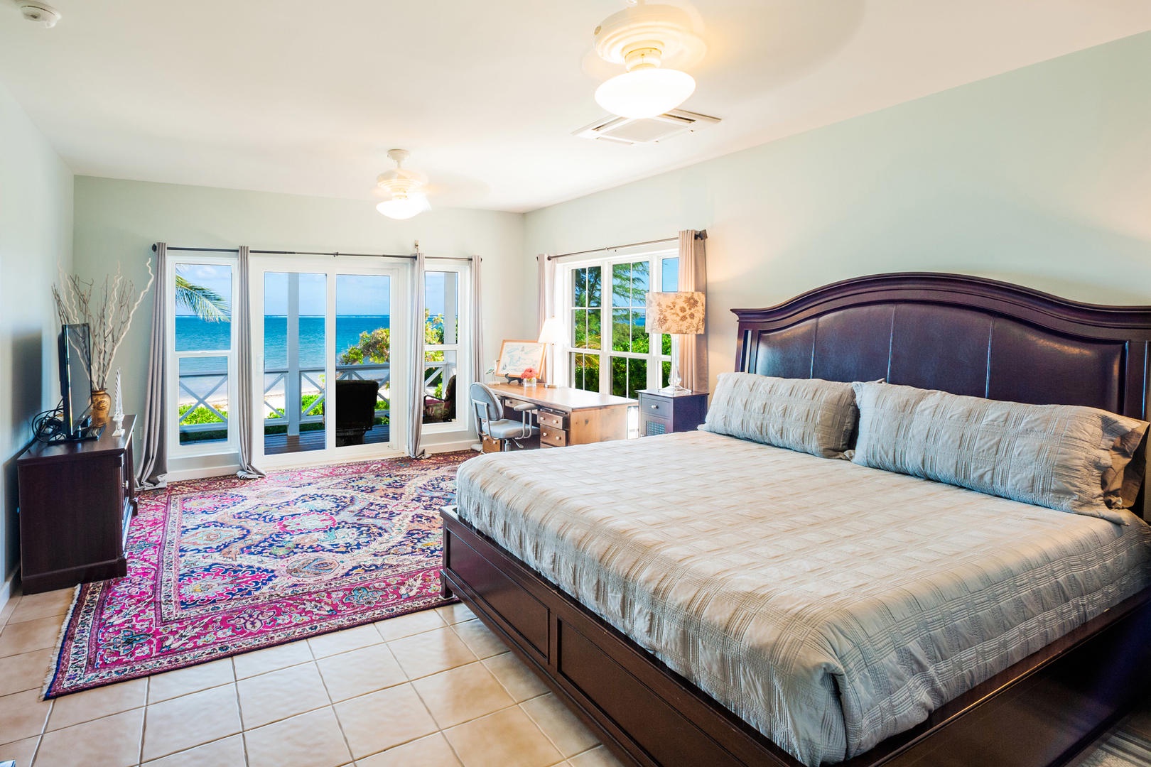 Bedroom 1 with king bed, television, and walkout access to the ocean veranda.