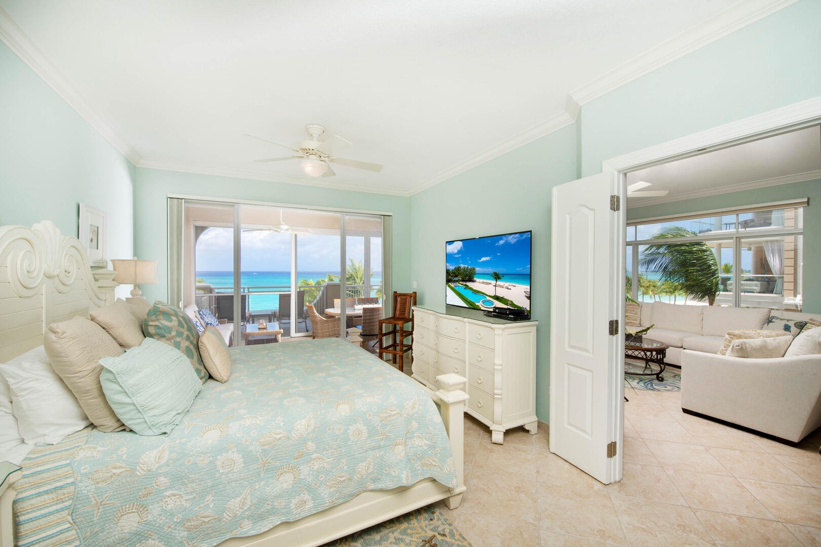 Primary suite with king size bed, television, and walkout access to the balcony.