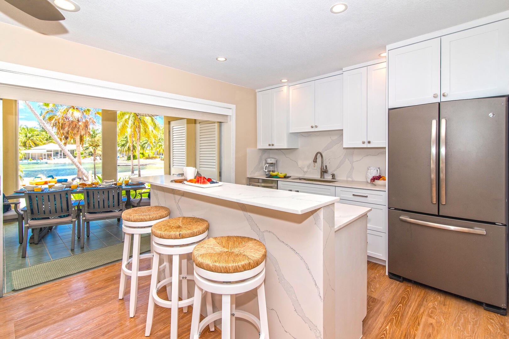 Full kitchen with island seating and walkout access to the atrium.
