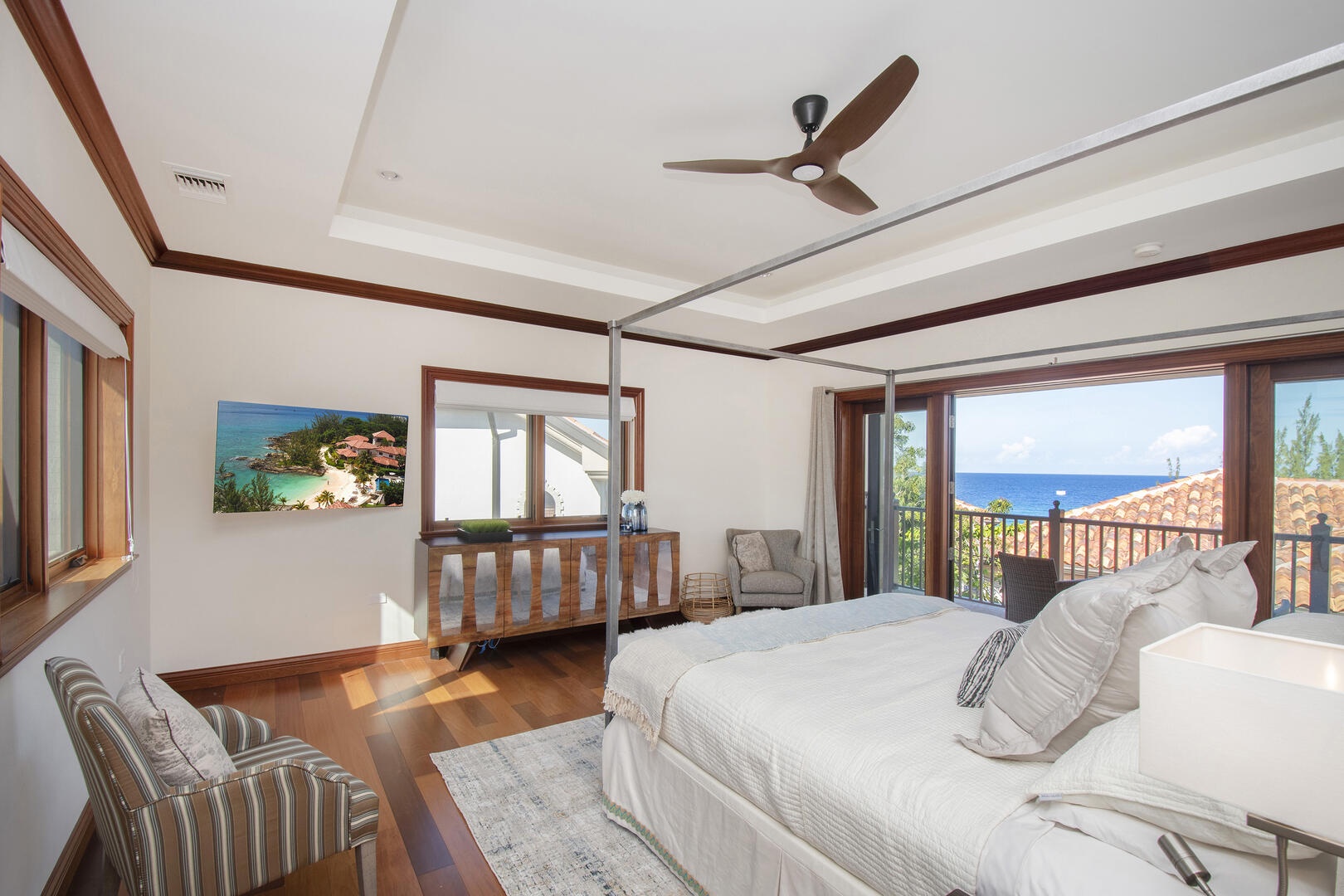 Master suite on the upper level with ocean views, television, and walk-out balcony.