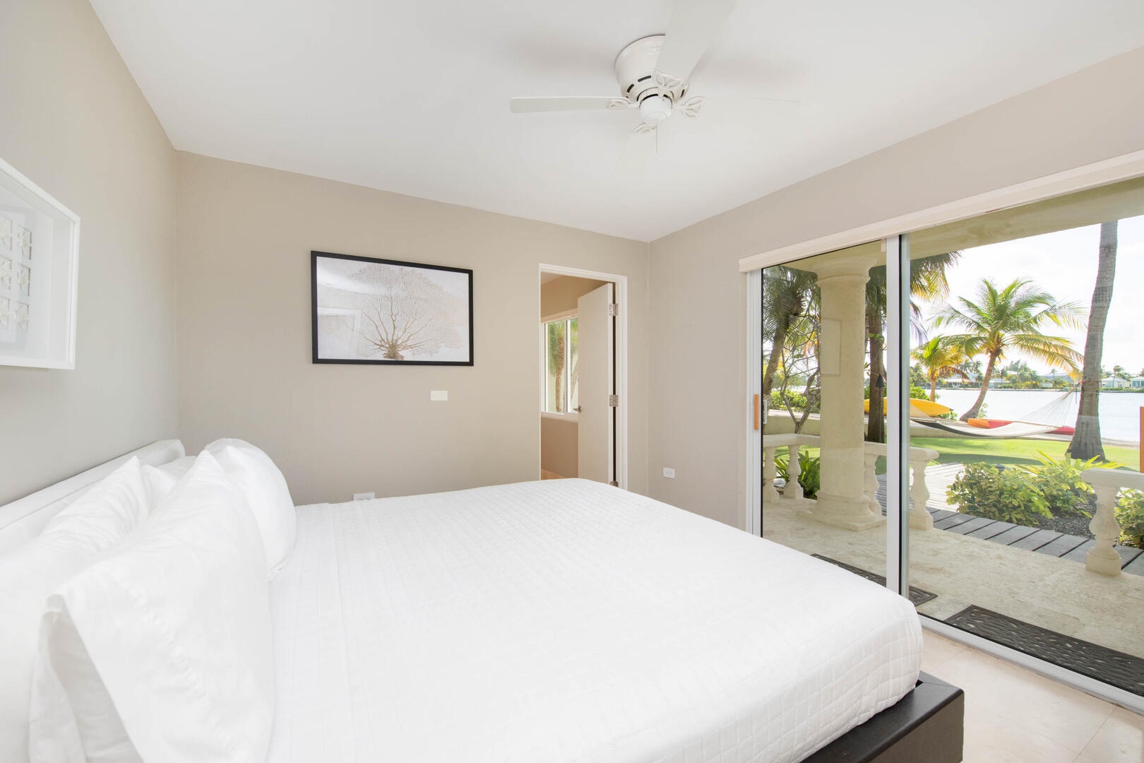 Lower Suite with king bed, waterfront views, and walkout access to the seaside hammock.
