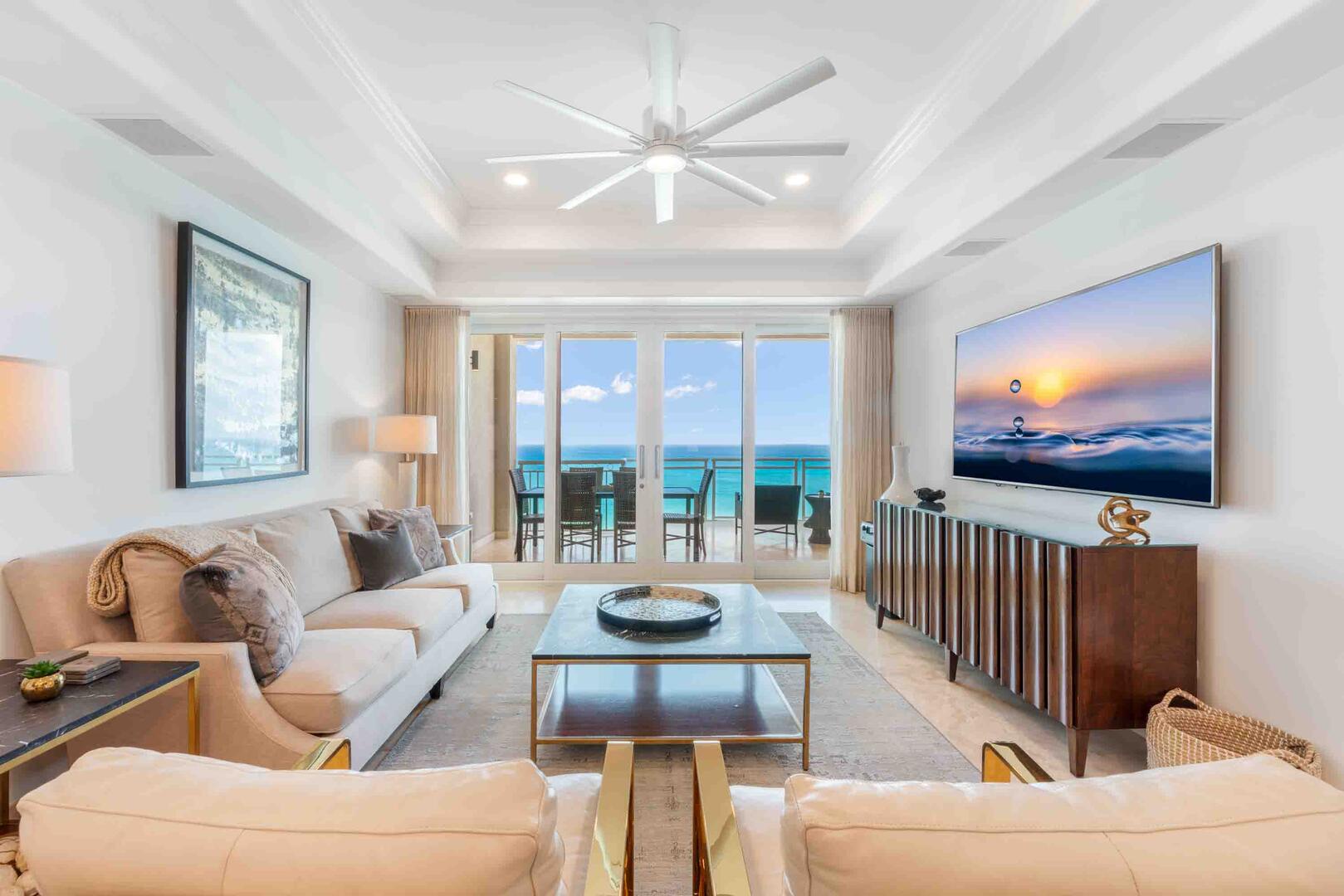 Living area with HD cable television, plush sofa seating, and walkout access to the ocean balcony.