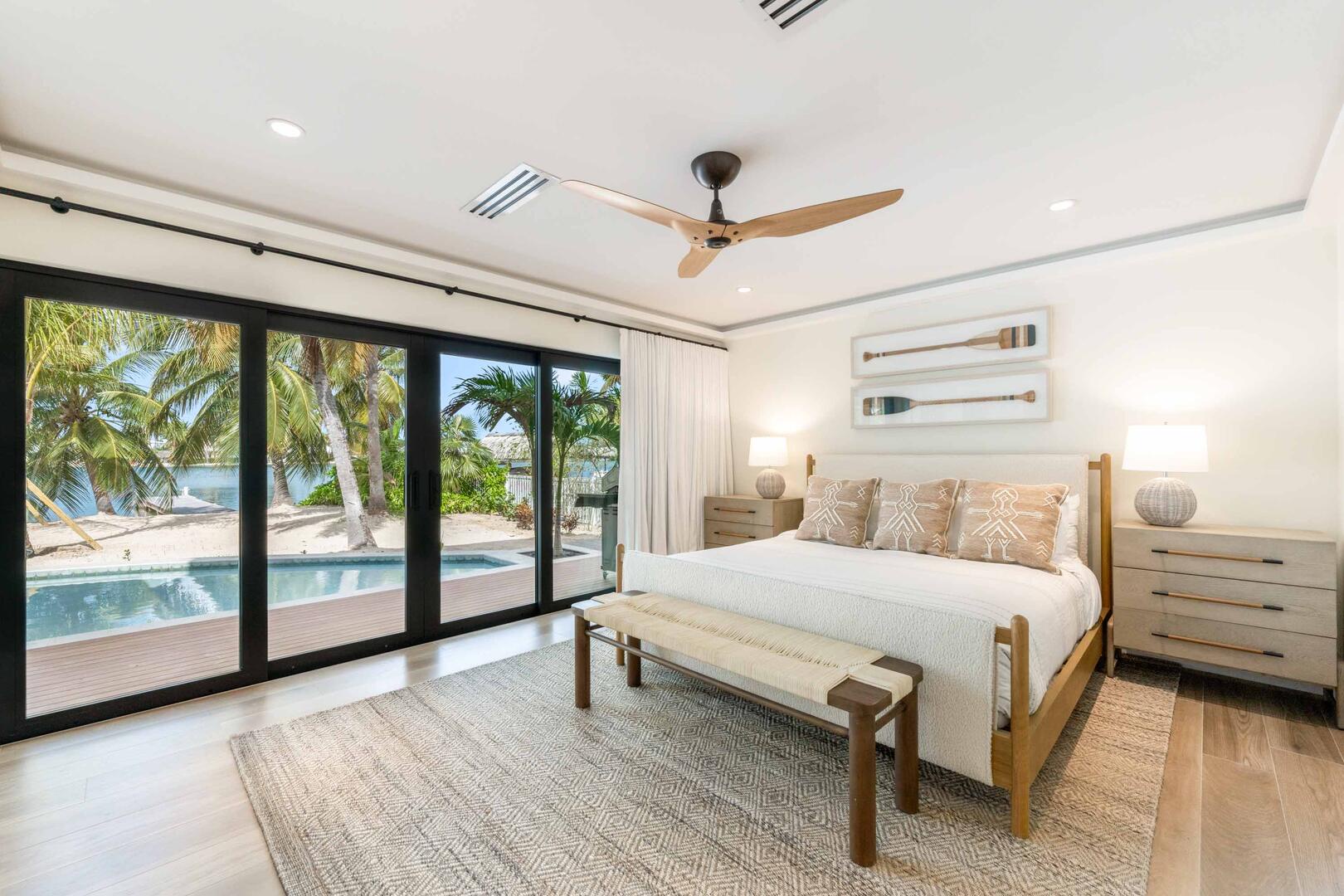 Bedroom 1 on the lower level with king bed and walkout access to the pool and beach.