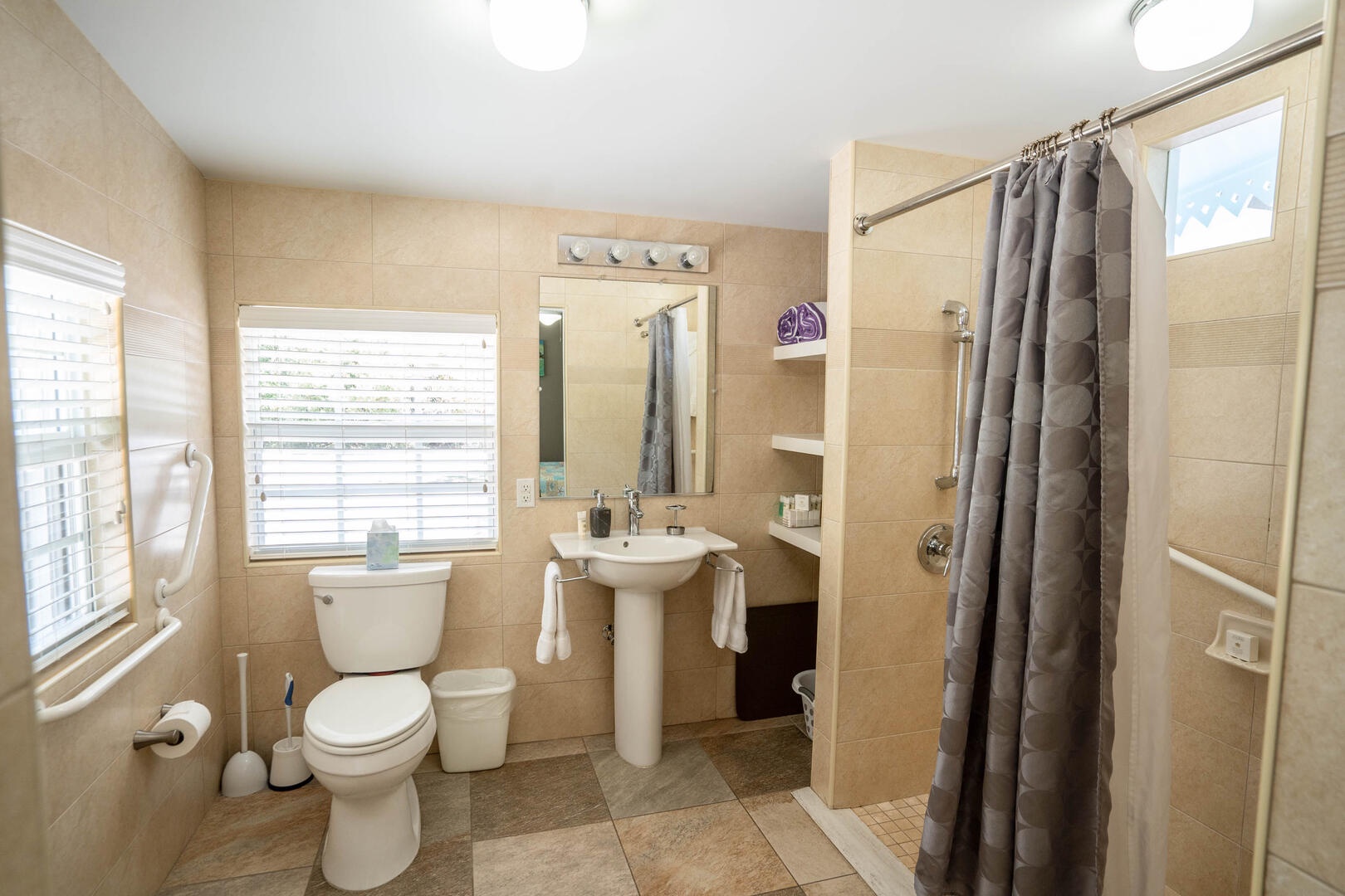 Primary ensuite equipped with multiple hand rails and a roll-in shower.