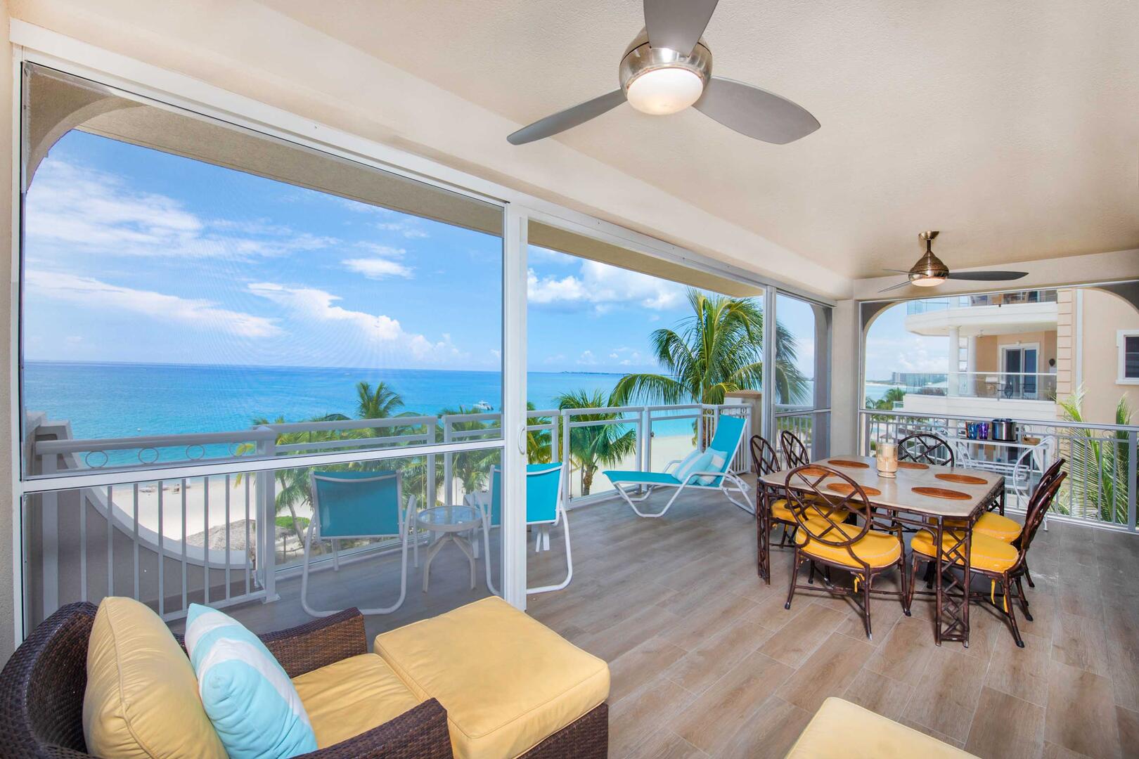 Furnished corner unit balcony with lounge seating and dining table.