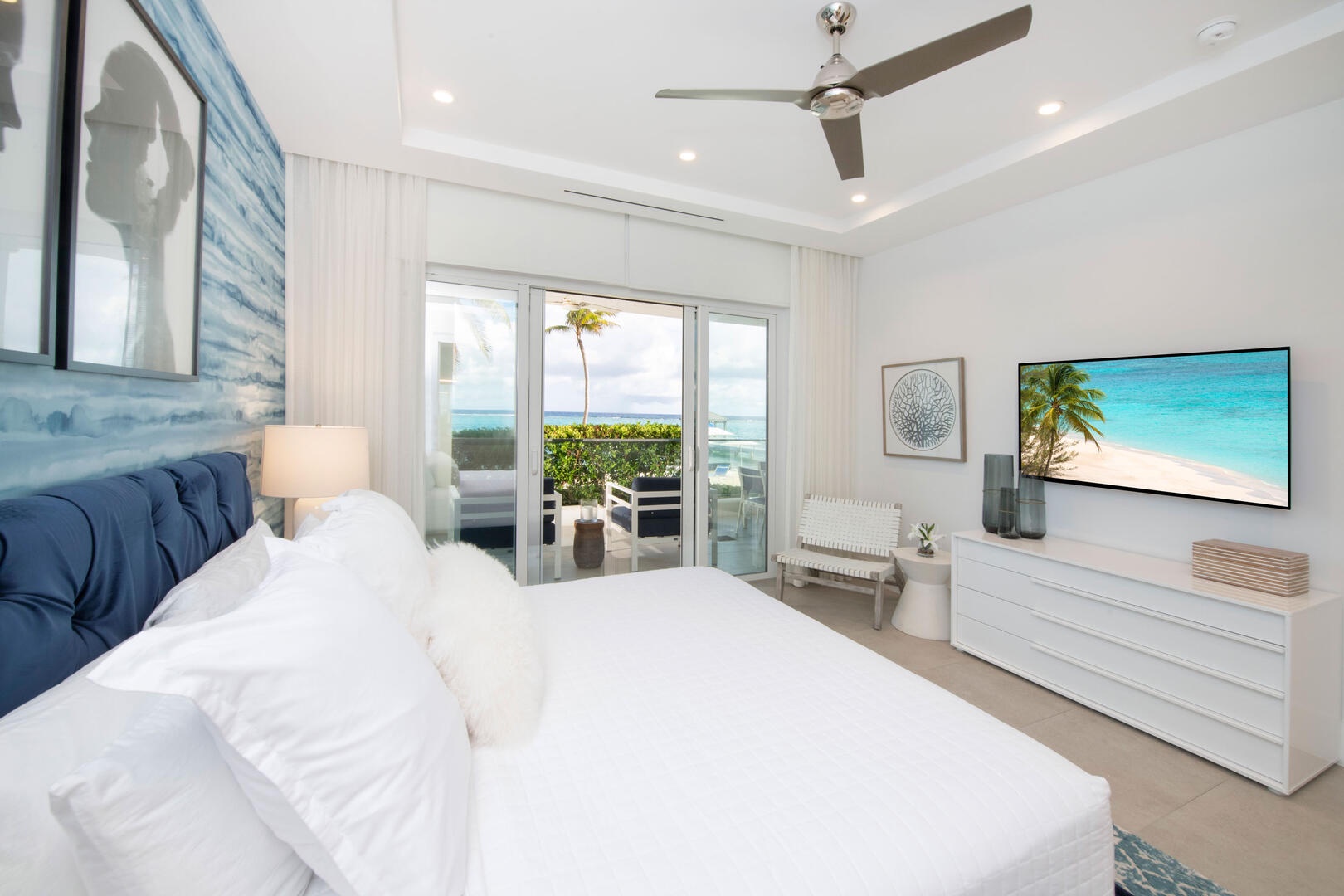 Primary Suite with king bed, television, and walk-out access to the balcony.