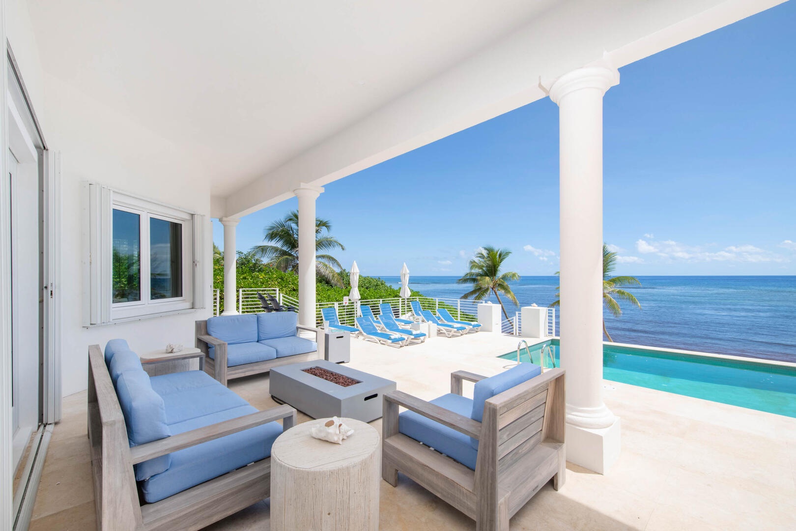 Veranda lounge area with propane fire pit and stellar ocean views.