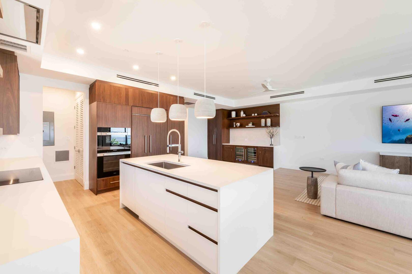 Modern kitchen with gourmet appliances. A wine bar sits opposite the kitchen.