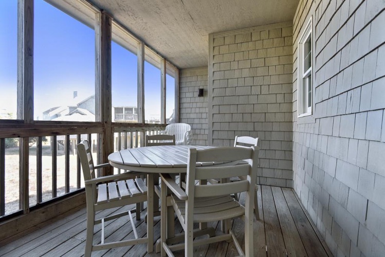 Relax on your private covered balcony with dining for four, perfect for morning coffee or evening meals while enjoying the coastal breeze and peaceful neighborhood views.