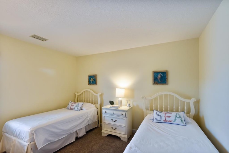 Rest easy in this cheerful coastal bedroom with twin beds, perfect for kids or friends sharing a room. Soft lighting and beach-themed decor create a peaceful retreat after your adventures.