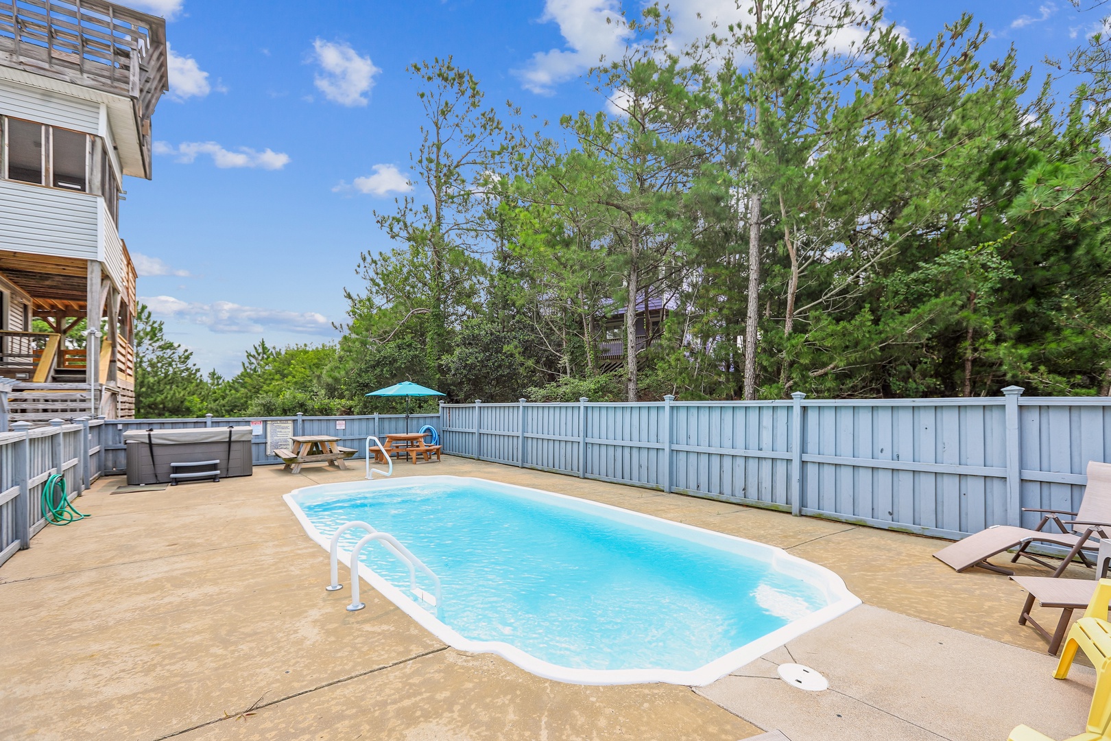 Your private pool oasis awaits, surrounded by a spacious deck with plenty of room to lounge, dine, and soak up the sunshine under clear blue skies.