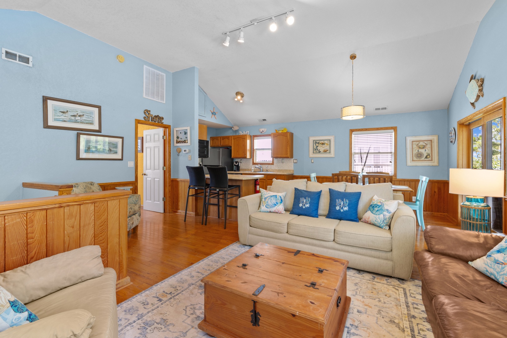 Unwind in this open-concept living space where coastal charm meets comfort. Sink into plush sofas, gather around the dining table, or whip up your favorite meal in the fully-equipped kitchen—all in one inviting area.