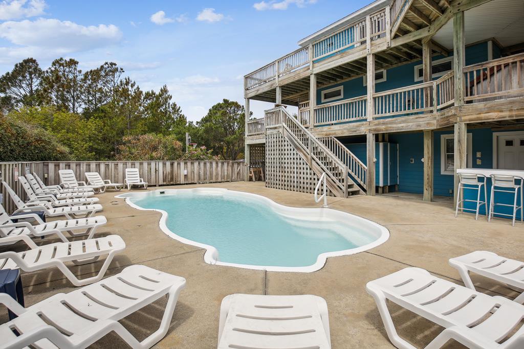 Your private pool awaits, surrounded by loungers and framed by spacious decks—perfect for sunny days of relaxation, poolside meals, and making memories with your group.