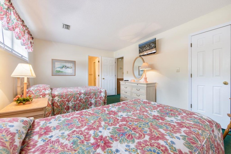 Sink into cozy floral bedding and unwind in your bright, welcoming bedroom, where soft lighting and homey touches invite restful nights and relaxed mornings.