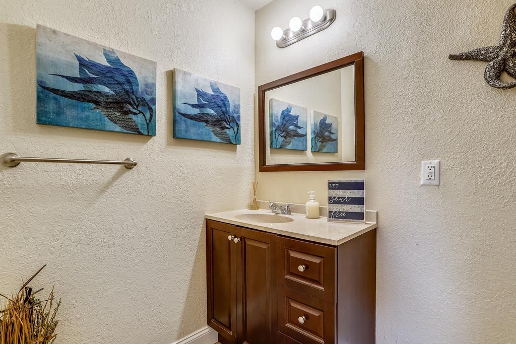 Unwind in your elegantly appointed bathroom, where coastal artwork and rich wood finishes create a serene, spa-like retreat for your stay.
