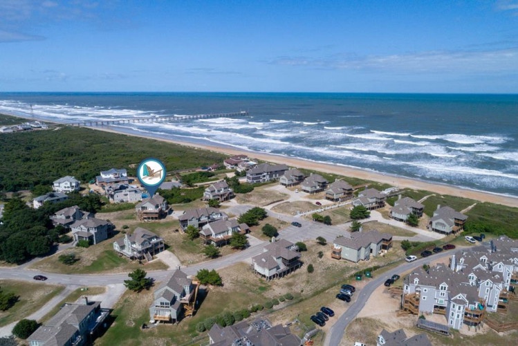Aerial view of a beachfront vacation rental community surrounded by natural coastal landscape and direct ocean access.