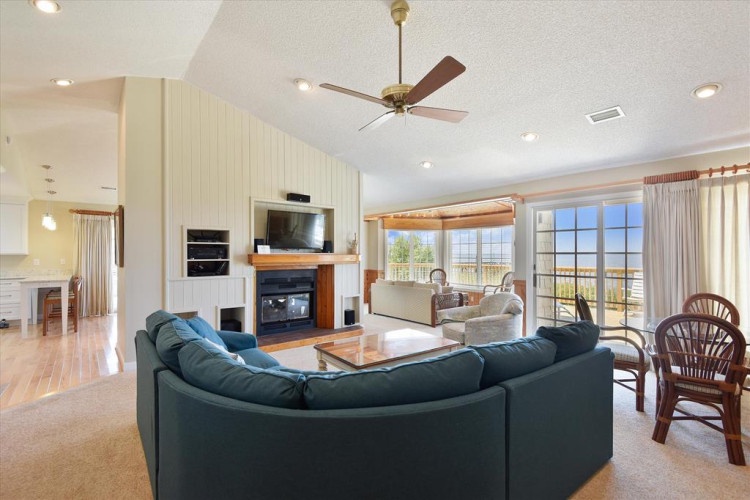 Step into your spacious retreat where vaulted ceilings and abundant natural light create an airy, welcoming atmosphere. Relax by the cozy fireplace or unwind on plush seating while enjoying stunning waterfront views through expansive windows.