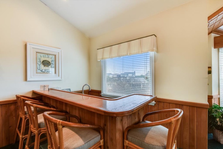 Gather around your private bar, complete with sink and stools—perfect for morning coffee or evening cocktails with views through the window.