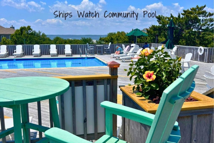 Relax by your sparkling community pool with ample lounge chairs, shaded seating, and vibrant floral touches overlooking serene water views.