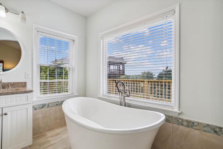 Soak away your cares in this elegant freestanding tub with natural light streaming in and peaceful views of the surrounding neighborhood to inspire your relaxation.