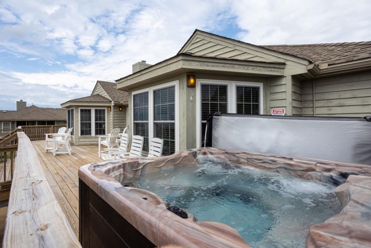 The outdoor deck offers a private hot tub, comfortable seating, and easy access to the main living areas—perfect for unwinding after a day of adventure or enjoying a quiet evening under the sky.
