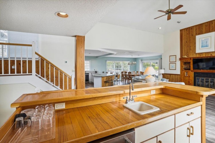 Enjoy this open-concept living space with vaulted ceilings and warm wood accents. The kitchen flows seamlessly into the dining and lounge areas, creating a perfect retreat for relaxation.