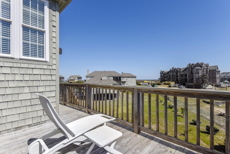 A private balcony with coastal neighborhood views frames the surrounding area and nearby homes, providing a peaceful spot to relax outdoors during your stay.