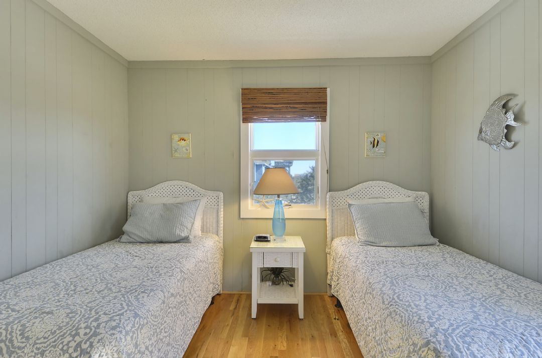 Your coastal retreat awaits with two cozy beds, charming décor, and soft natural light. Settle in and feel instantly at home in this peaceful space.