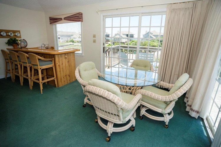 Your dining area opens onto a private balcony with peaceful neighborhood views, where you can enjoy morning coffee or evening meals with fresh coastal breezes drifting in.