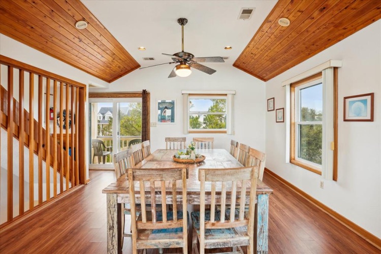 Gather around this handsome farmhouse table with natural light streaming through large windows and the gentle spin of your ceiling fan overhead.