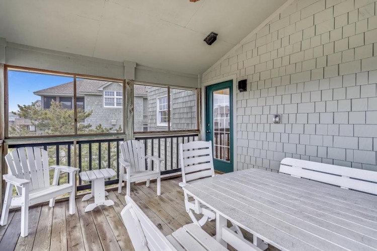 Step onto your private screened porch, where white Adirondack chairs and a picnic table invite you to unwind with morning coffee or evening conversation in complete comfort.